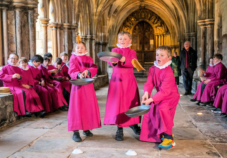 Pancake race fun in Norwich cathedral cloisters